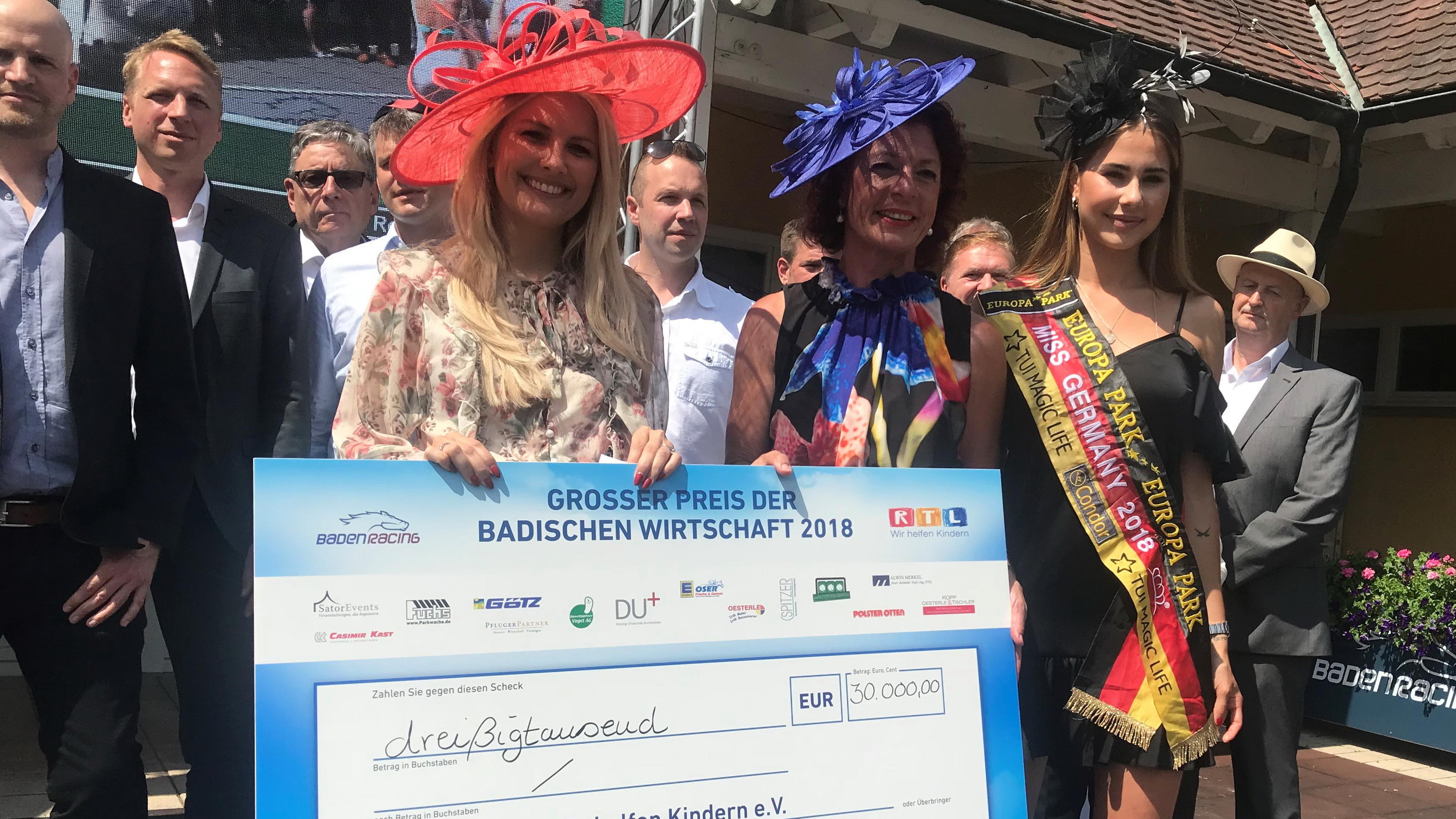 Charity Pferderennen in Iffezheim mit Jennifer Knäble: 30.000 Euro beim Baden-Racing! RTL-Moderatorin Jennifer Knäble, Baden Racing Geschäftsführerin Jutta Hofmeister und die amtierende Miss Germany Anahita Rehbein (v. li.) bei der Scheckübergabe von 30.000 Euro zu Gunsten von "RTL - Wir helfen Kindern" beim Baden Racing 2018.