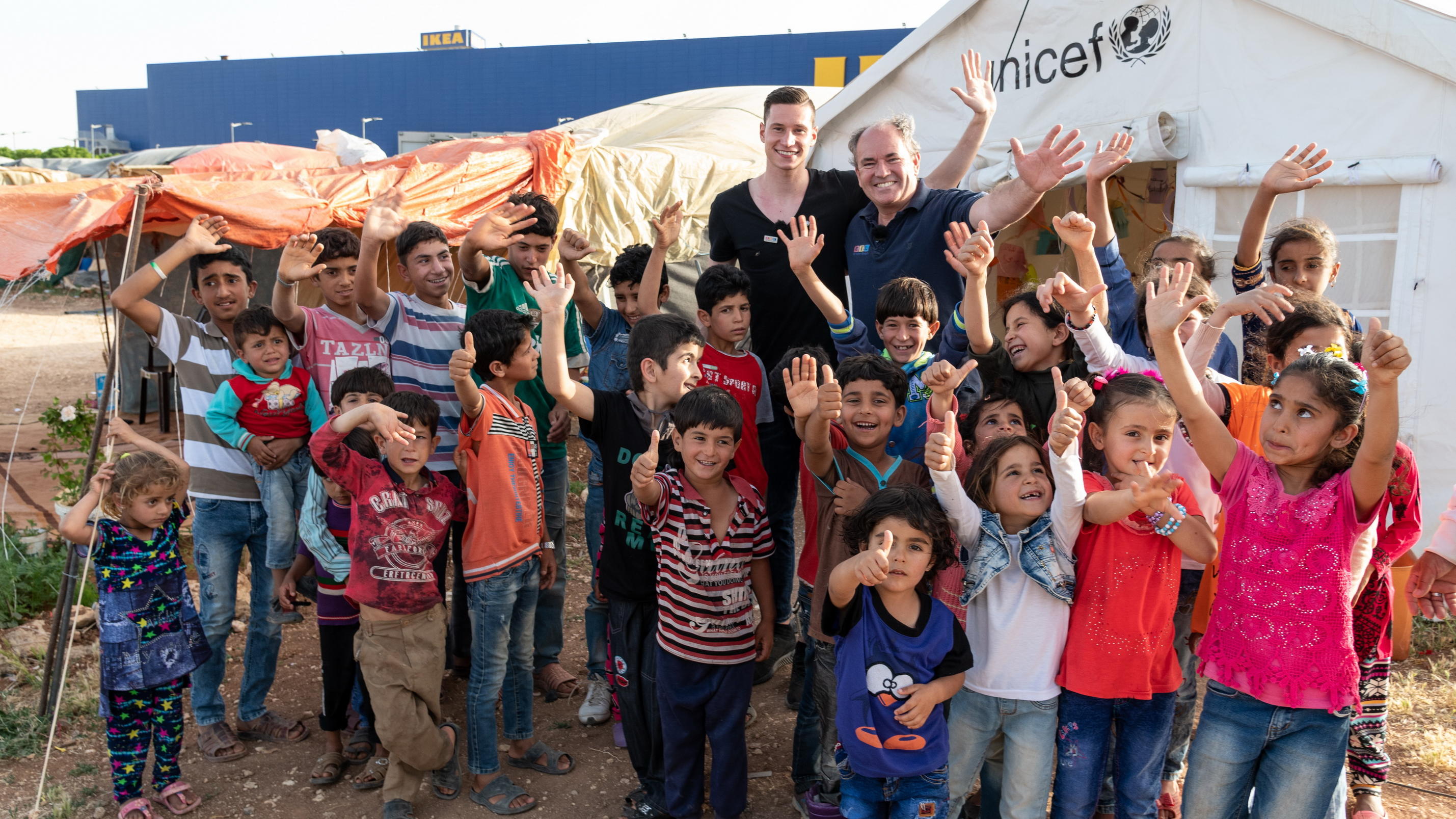"RTL – Wir helfen Kindern"-Pate Julian Draxler besucht Flüchtlingslager in Jordanien "RTL – Wir helfen Kindern“-Pate Julian Draxler und Wolfram Kons (Vorstand „Stiftung RTL – Wir helfen Kindern e.V.“) mit Flüchtlingskindern in Zaatari.