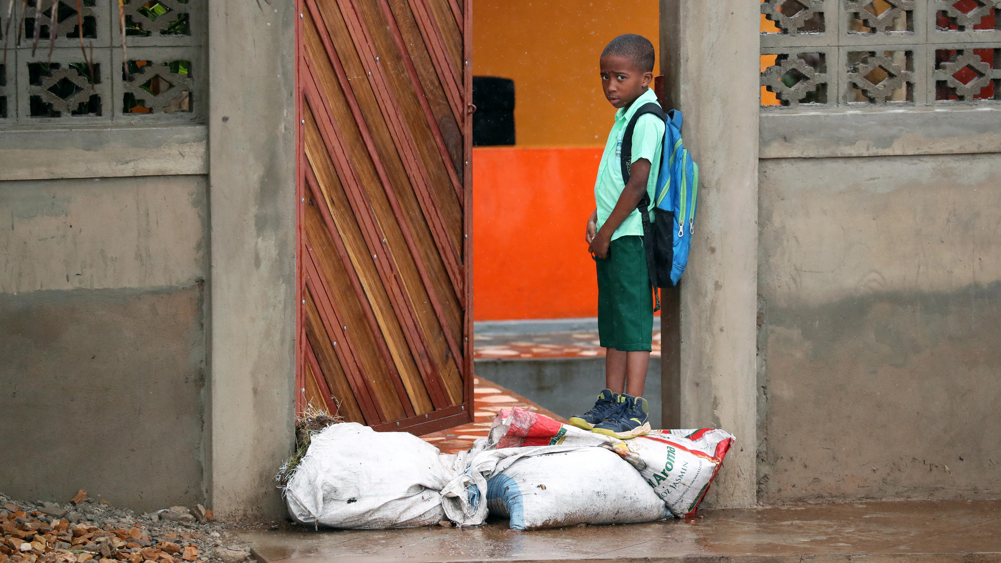 Neuer Zyklon in Mosambik: Zehntausende Kinder und ihre Familien kämpfen ums Überleben! Ein Kind steht hinter Sandsäcken, die zum Schutz vor Überschwemmungen nach dem Zyklon Kenneth in Pemba aufgestellt wurden. April 29, 2019. REUTERS/Mike Hutchings
