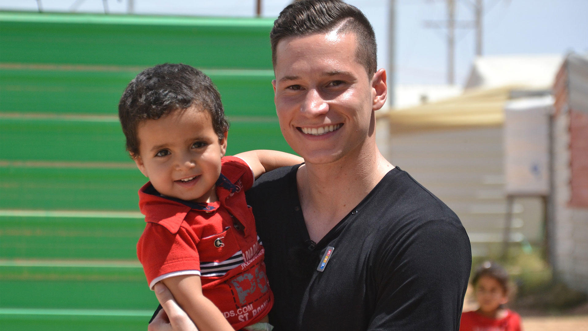Zumba und ein großes Dankeschön: „RTL – Wir helfen Kindern"-Pate Julian Draxler tanzt vor Freude! Julian Draxler mit einem syrischen Flüchtlingskind.