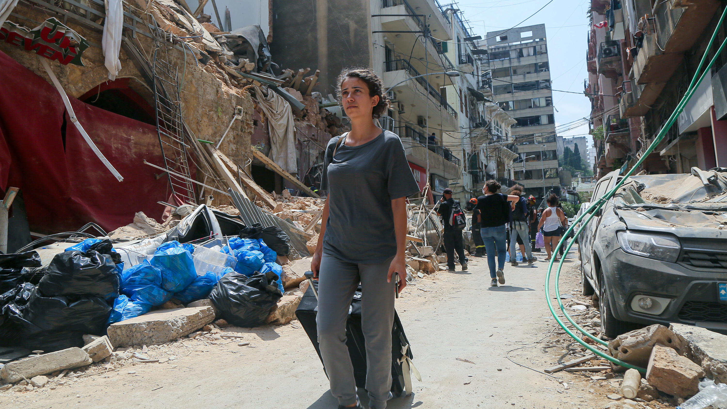 Spenden Sie! Soforthilfe für betroffene Familien und deren Kinder in Beirut! 06.08.2020, Libanon, Beirut: Eine Anwohnerin steht vor ihrem Haus im Stadtviertel Achrafieh, das durch die Explosion im Hafen schwer beschädigt wurde. Der französische Präsident Macron sollte das Viertel besuchen, aber seine Tour musste abgesagt werd
