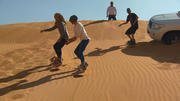 Die Jungs entspannen beim Sandboarding Die Jungs entspannen beim Sandboarding