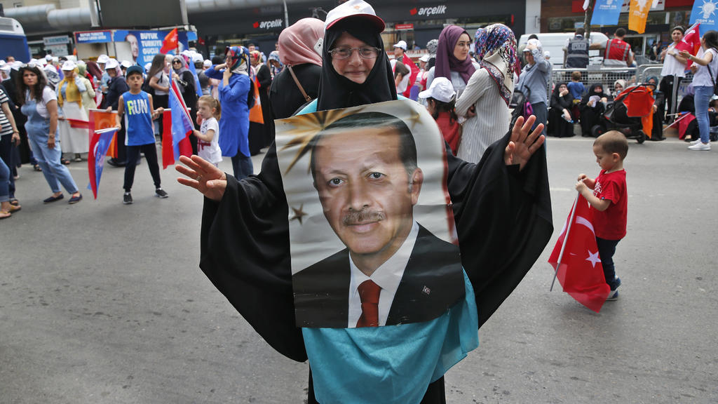 Eine Unterstützerin des türkischen Präsidenten Erdogan trägt ein Bild von Erdogan bei einer Wahlkampfveranstaltung der Regierungspartei AKP. Am 24. Juni finden erstmals zeitgleich die Präsidenten- und die Parlamentswahle