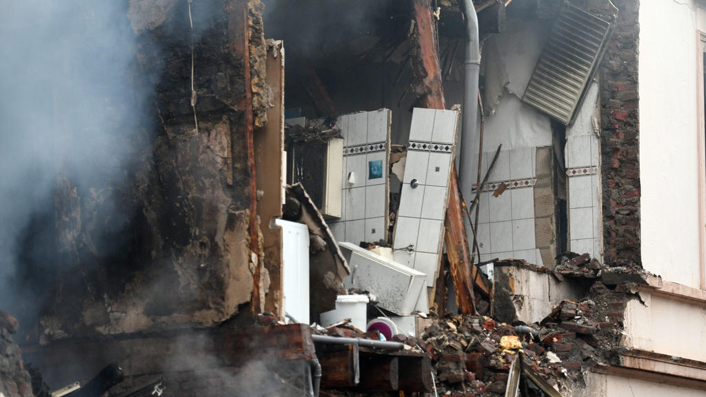 24.06.2018, Nordrhein-Westfalen, Wuppertal: Rauch steigt aus den Trümmern eines Hauses auf, in dem es in der Nacht eine Explosion gegeben hat. Bei einer Explosion in einem Wohnhaus in Wuppertal sind 24 Menschen verletzt worden. Foto: Henning Kaiser/d