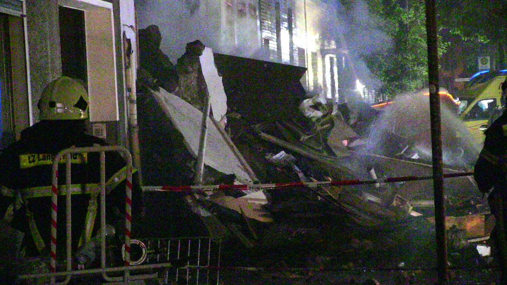 24.06.2018, Nordrhein-Westfalen, Wuppertal: Feuerwehrmänner stehen vor Trümmern eines Wohnhauses. Bei einer Explosion in dem Gebäude sind 24 Menschen verletzt worden. Foto: Gianni Gattus/Blaulicht Solingen/dpa +++ dpa-Bildfunk +++