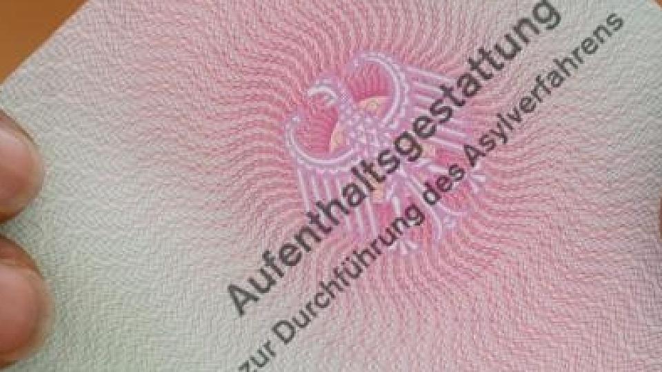 Flüchtling mit einer Aufenthaltsgestattung in den Händen. Juristische Schritte gegen das Bundesamt wagen vorwiegend Menschen, die sich eine hohe Chance ausrechnen, dass ihrem Asylantrag stattgegeben wird. Foto: Arne Dedert/Symbolbild