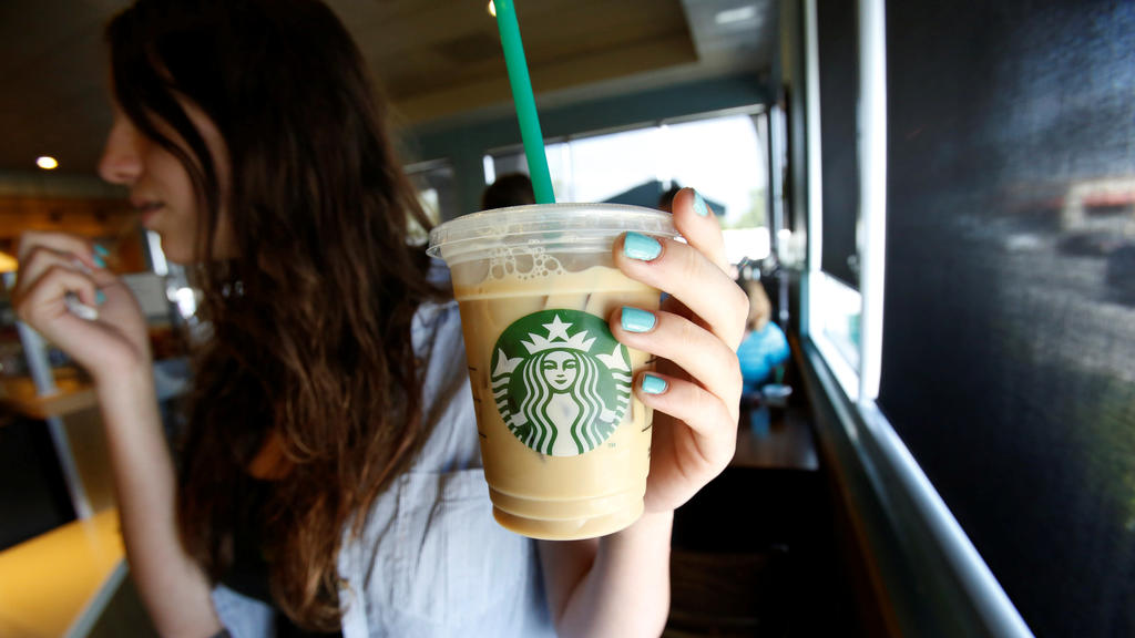 FILE PHOTO: A patron holds an iced beverage with a straw, at a Starbucks coffee store in Pasadena, California, U.S., July 25, 2013. REUTERS/Mario Anzuoni/File Photo