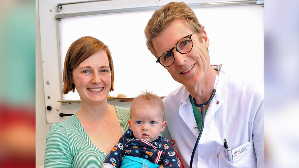 HANDOUT - 15.06.2018, Bayern, München: Der kleine Faustus ist auf dem Arm seiner Mutter Fanny B. und lässt sich gemeinsam mit Peter Ewert, Direktor der Klinik für Angeborene Herzfehler/Kinderkardiologie am Deutschen Herzzentrum München, porträtieren.