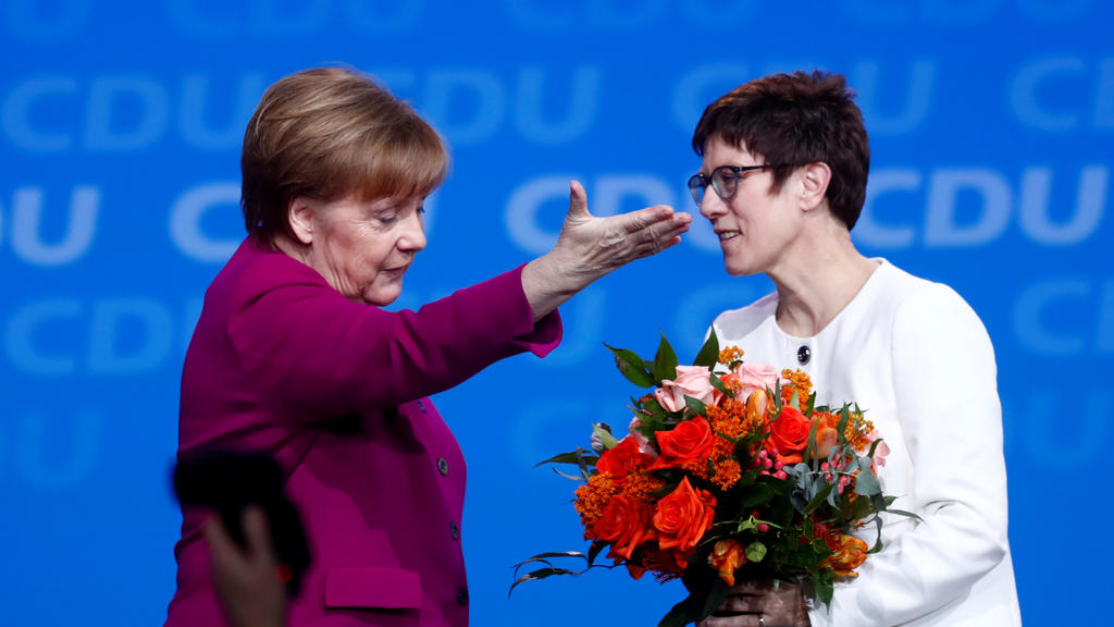FILE PHOTO: German Chancellor Angela Merkel gestures beside Annegret Kramp-Karrenbauer after she was elected secretary general during a Christian Democratic Union (CDU) party congress in Berlin, Germany, February 26, 2018. REUTERS/Hannibal Hanschk