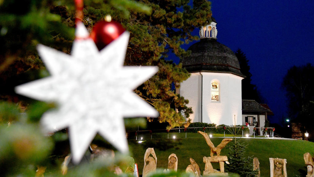 23.11.2018, Österreich, Oberndorf: Ein Weihnachtsstern mit den Noten zum möglicherweise bekanntesten Weihnachtslied der Welt hängt vor der Stille Nacht-Kapelle in Oberndorf bei Salzburg. 2018 feiert ·Stille Nacht! Heilige Nacht!· seinen 200. Geburtst