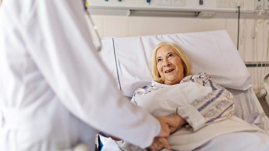 Eine Patientin im Krankenhaus im Gespräch mit einem Arzt.