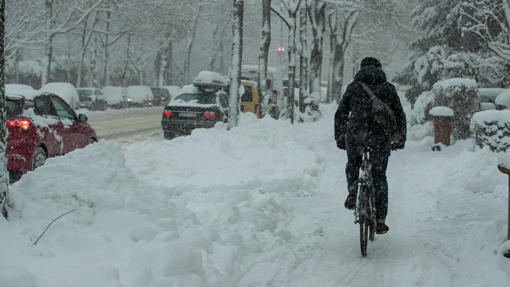 Starker Schneefall in München, Trotz hohem Schnne fährt hier ein Mensch mit dem Fahrrad. Weiterhin schneit es in München. Viele Straßen sind komplett weiß. München Bayern Deutschland Schwabing *** Heavy snowfall in Munich In spite of high snowfall, a