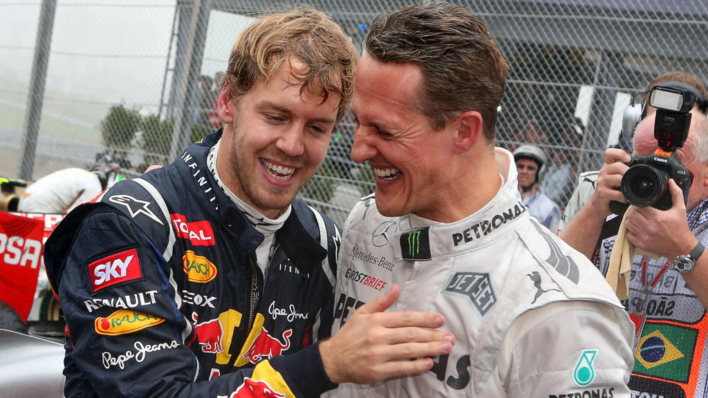 ARCHIV - 25.11.2012, Brasilien, São Paulo: Der deutsche Formel-1-Fahrer Sebastian Vettel (l) feiert mit Michael Schumacher im Autodromo Jose Carlos Pace seinen dritten Weltmeistertitel in Folge. (zu dpa "Vettel erinnert sich an Momente mit Vorbild Sc