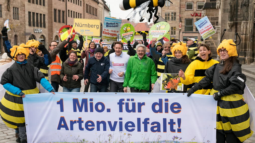Agnes Becker (ÖDP, M,l-r), Norbert Schäffer (LBV), Ludwig Hartmann (Bündnis 90/Die Grünen) und Richard Mergner (Bund Naturschutz) stehen zusammen mit Unterstützern des Volksbegehrens