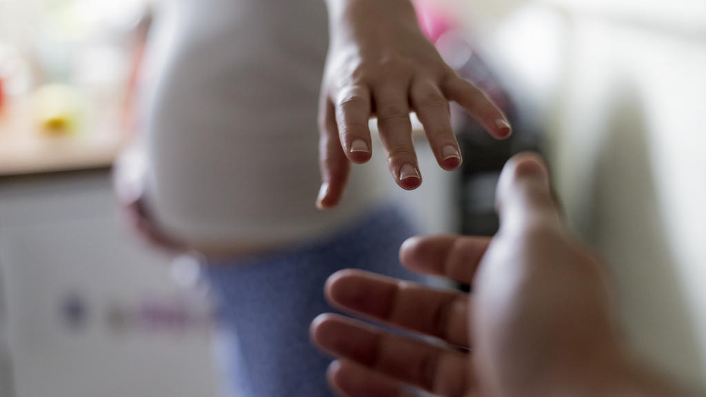 Schwangere Frau bekommt eine helfende Hand gereicht