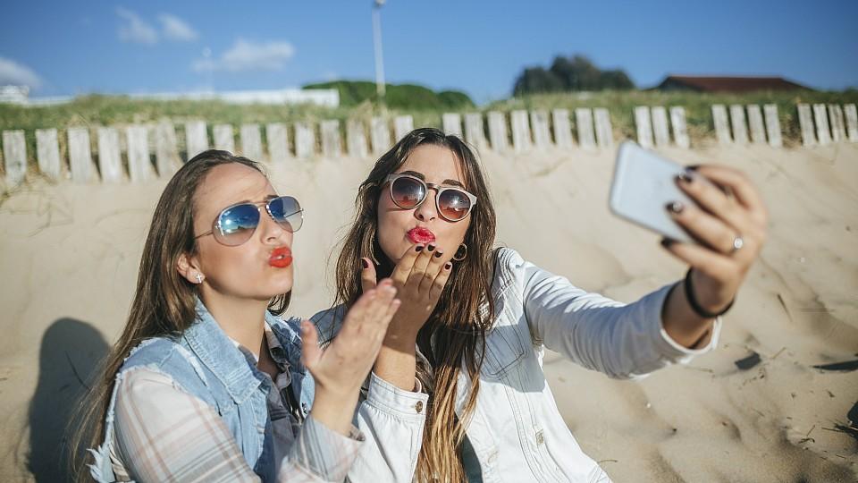 Two young women taking selfie on the beach while blowing a kiss model released Symbolfoto PUBLICATIONxINxGERxSUIxAUTxHUNxONLY KIJF01308Two Young Women Taking Selfie ON The Beach while blowing a Kiss Model released Symbolic image PUBLICATIONxINxGERxSU