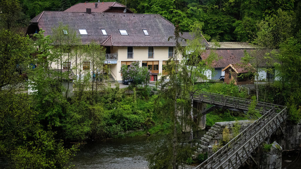 11.05.2019, Bayern, Passau: Eine Pension steht von Bäumen umgeben an der Ilz. Drei tote Personen sind in einem Zimmer der Pension gefunden worden. Den Angaben zufolge stammen die Toten aus Niedersachsen und Rheinland-Pfalz. Es sei noch völlig offen,