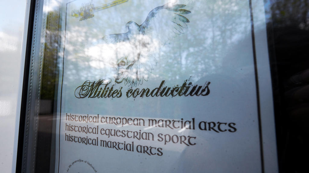 14.05.2019, Rheinland-Pfalz, Hachenburg: Ein Werbeplakat hängt im Schaufenster eines Mittelalterladen. Diesen Laden betrieb ein 53-Jähriger, der am Wochenende leblos in einer Pension rund 600 Kilometer entfernt in Passau gefunden wurde - Hand in Hand