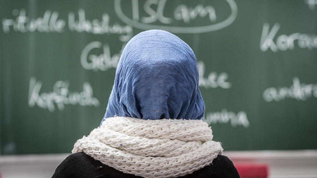 ARCHIV - 05.02.2015, Hessen, Frankfurt/Main: Eine Schülerin mit Kopftuch sitzt an der Johann Hinrich Wichern-Schule bei einer Unterrichtsstunde zum Thema Islam vor einer Tafel. Schleswig-Holsteins Bildungsministerin Prien (CDU) sieht Kopftücher bei G