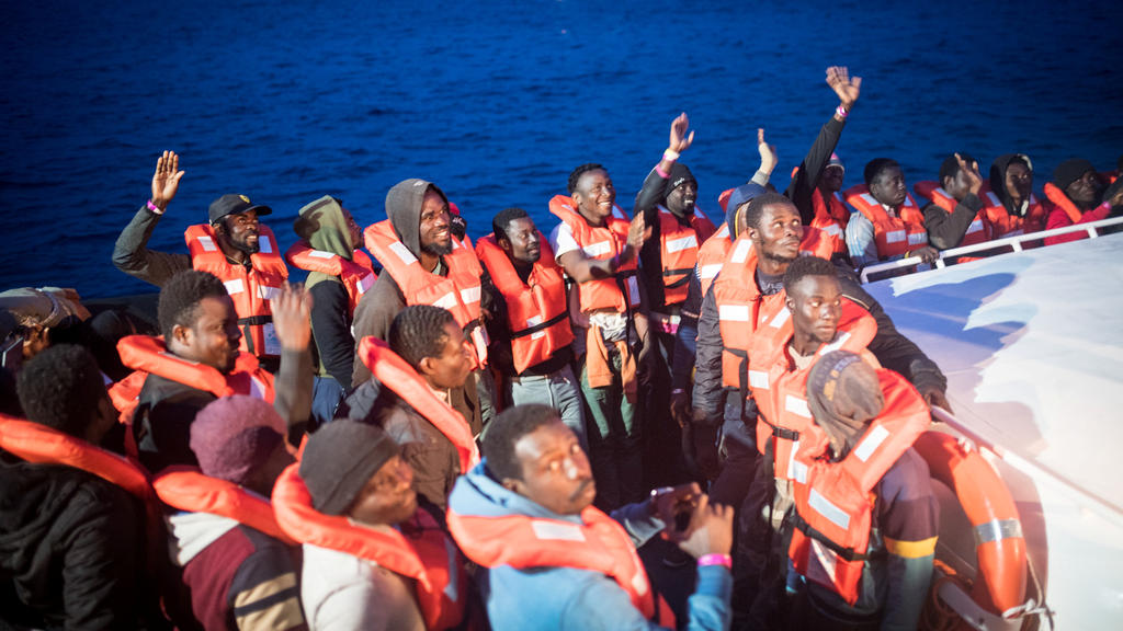 Migrants gesture as they are transferred from the Sea Watch 3 German charity ship to an Italian naval vessel heading for the island of Lampedusa, Italy May 19, 2019. Picture taken May 19, 2019. Nick Jaussi/Sea-Watch/Handout via REUTERS ATTENTION EDIT