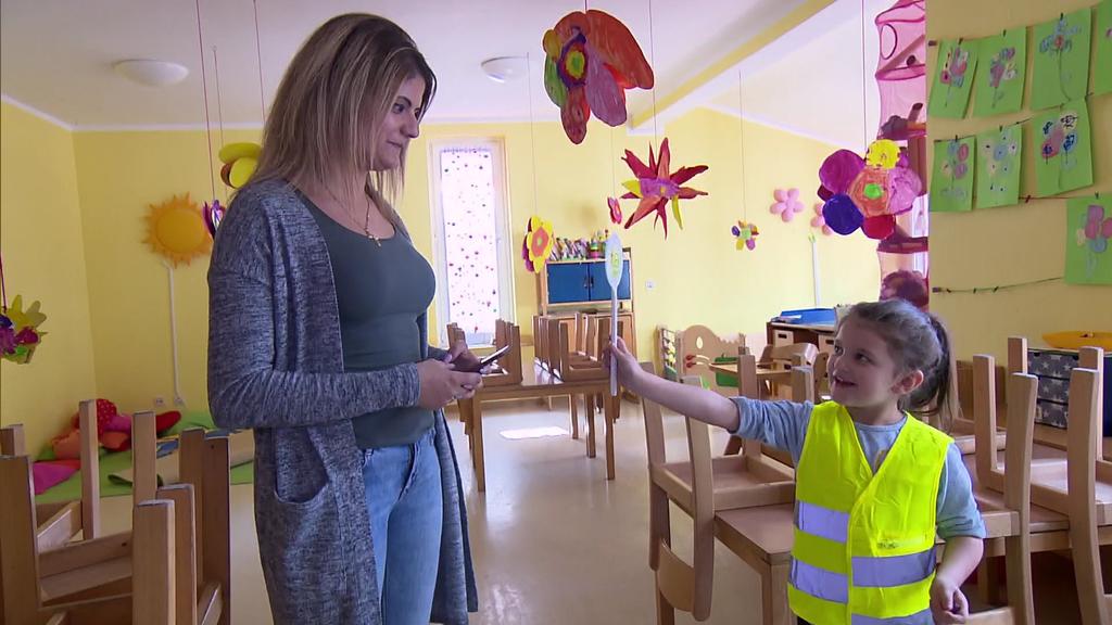 Elisa und ihre Mutter finden die Idee gut, dass Eltern in Kitas die Handys weg lassen. Töchterchen zeigt ihrer Mutter die "Handy-weg"-Kelle
