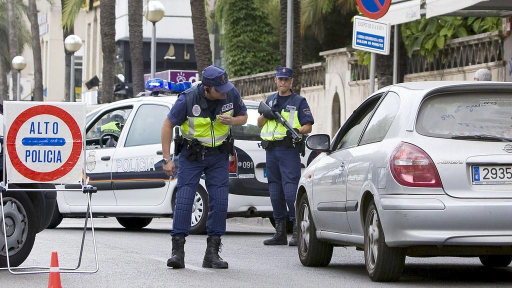 Spanish National Police officers inspect cars at a roadblock in downtown Palma de Mallora, Balearic Islands on 10 August 2009, one day after three small bombs exploded in places frequented by tourists in the capital of the island of Mallorca. Few clu