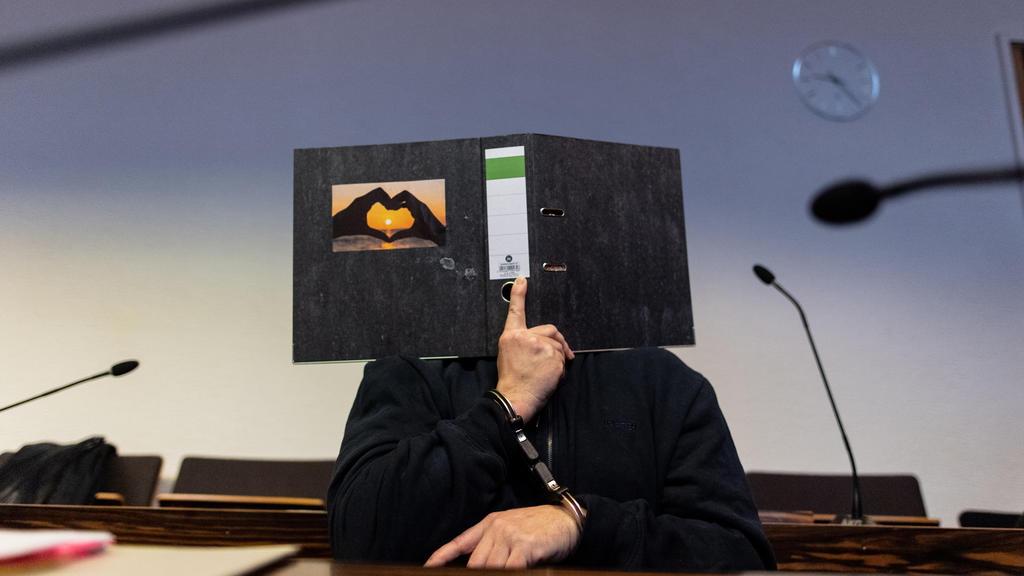 ARCHIV - 08.05.2019, Baden-Württemberg, Freiburg: Der 58-jährige Angeklagte sitzt im Gerichtssaal im Landgericht und hält einen Aktenordner mit einem Herz aus zwei Händen vor sein Gesicht. Ihm werden die Entziehung Minderjähriger und schwerer sexuell
