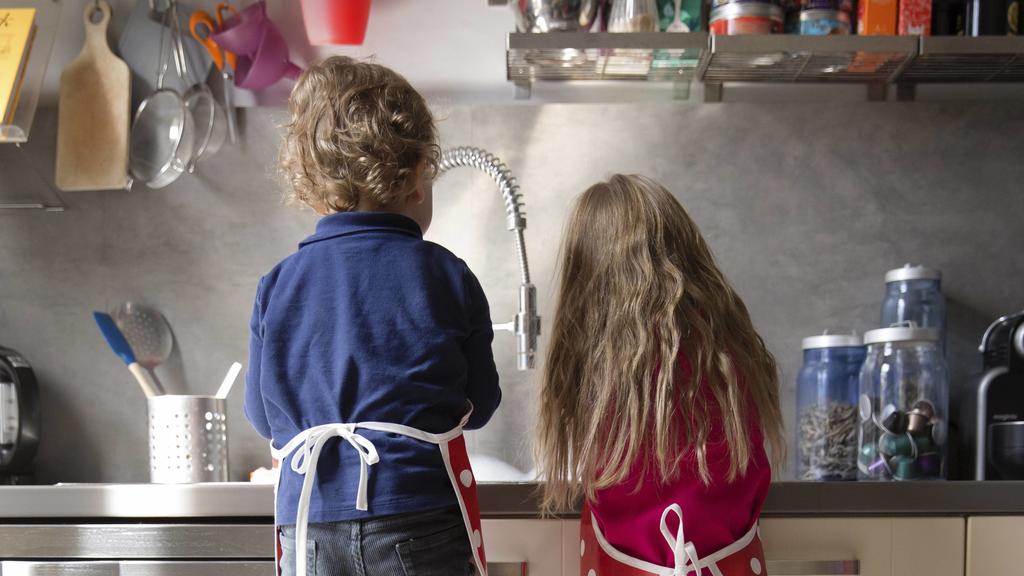 Back view of little boy and girl washing dishes in the kitchen model released Symbolfoto property released PUBLICATIONxINxGERxSUIxAUTxHUNxONLY LITF000235