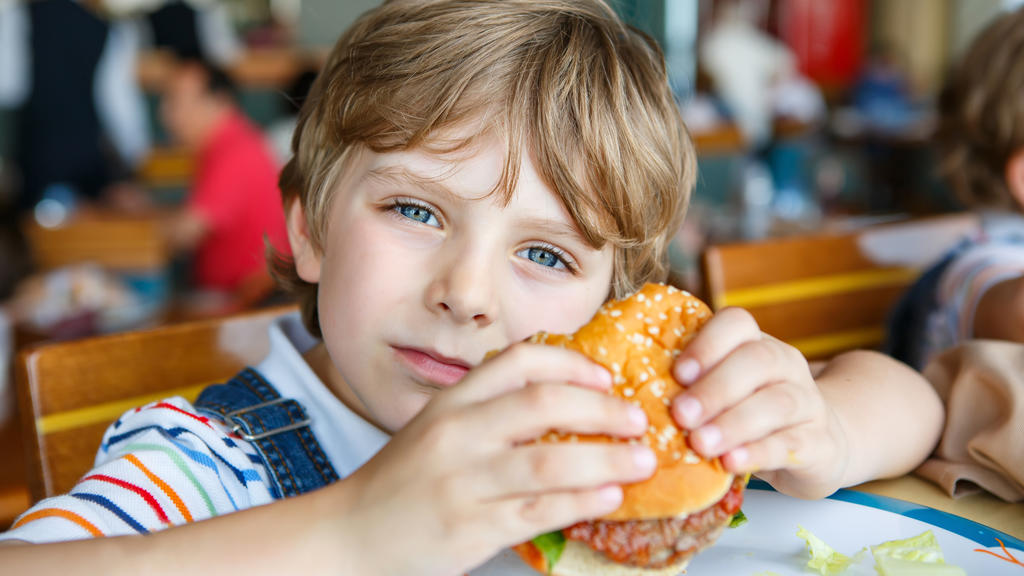Junge isst Burger.
