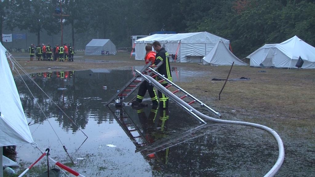 11.07.2019, Niedersachsen, Dersum: Feuerwehrleute sind auf einem Zeltplatz im Einsatz. Nach heftigen Regenfällen musste das Jugendzeltlager bei Papenburg evakuiert werden. Die Jugendlichen wurden in einem örtlichen Schützenhaus untergebracht. (bestmö