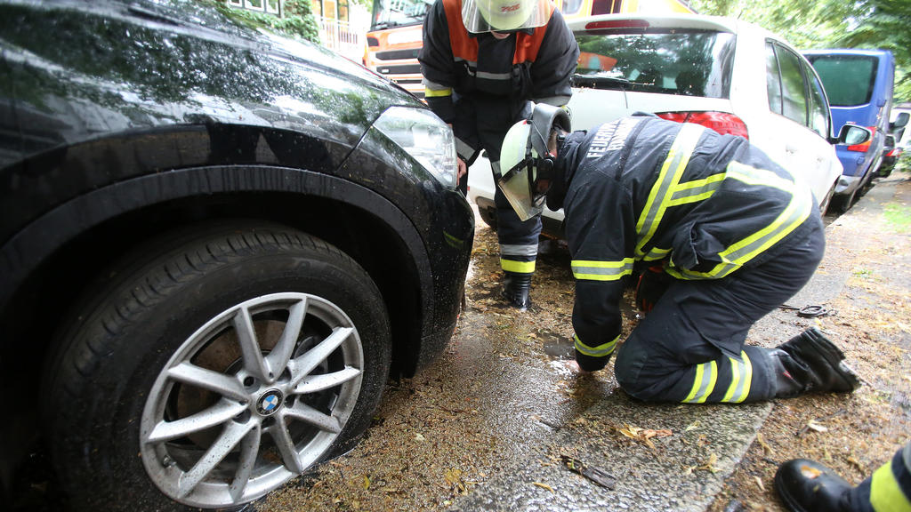 20.07.2019, Hamburg: Feuerwehrleute heben bei einem wetterbedingten Einsatz einen Gullideckel hoch, damit aufgestautes Regenwasser abfließen kann. Eine Gewitterfront ist am Samstagnachmittag über Hamburg und Schleswig-Holstein gezogen. Foto: Bodo Mar