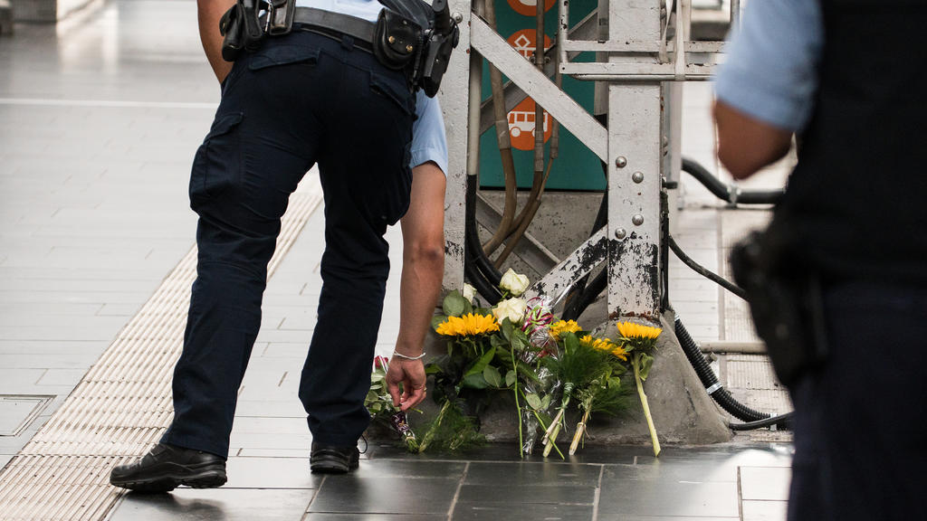 29.07.2019, Hessen, Frankfurt/Main: Ein Polizist legt an einer Stelle im Hauptbahnhof Blumen nieder. Ein achtjähriger Junge ist im Frankfurter Hauptbahnhof von einem Mann vor einen einfahrenden ICE gestoßen und getötet worden. Ein Tatverdächtiger wur