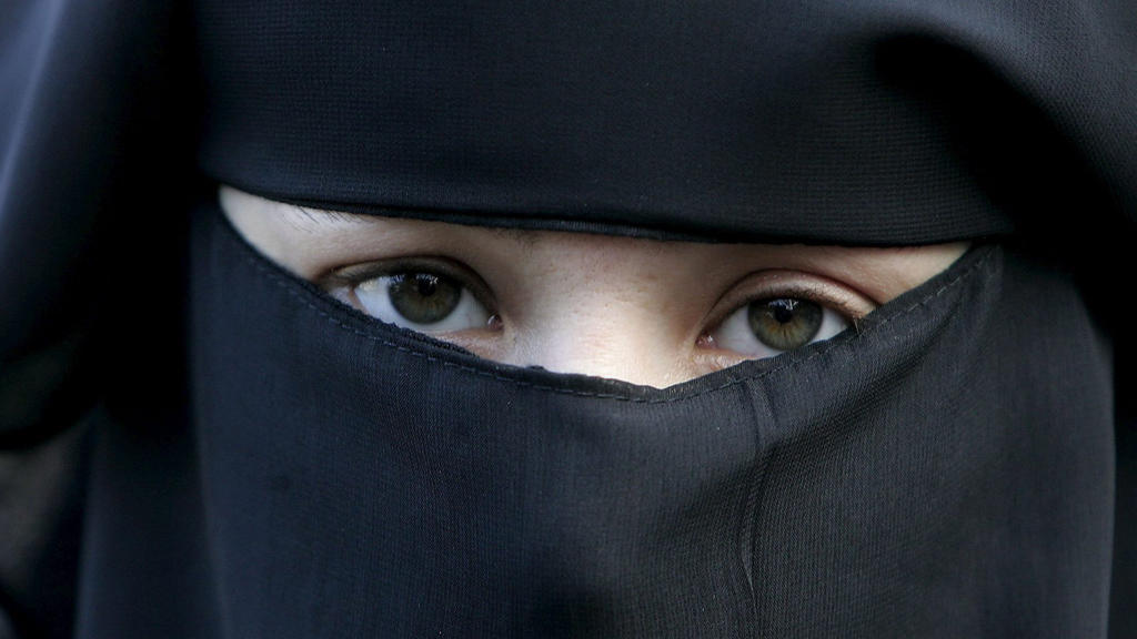 ARCHIV - 30.11.2006, Niederlande, Den Haag: Eine Frau trägt bei einer Demonstration gegen das Verbot einer vollverschleierung einen Nikab. Nach einer heftigen Debatte von mehr als zehn Jahren ist ab Donnerstag 1. August «gesichtsbedeckende» Kleidung