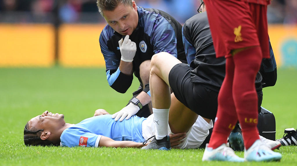 LONDON, ENGLAND - AUGUST 04: Leroy Sane of Manchester City receives medical attention during the FA Community Shield match between Liverpool and Manchester City at Wembley Stadium on August 04, 2019 in London, England. (Photo by Michael Regan/Getty I