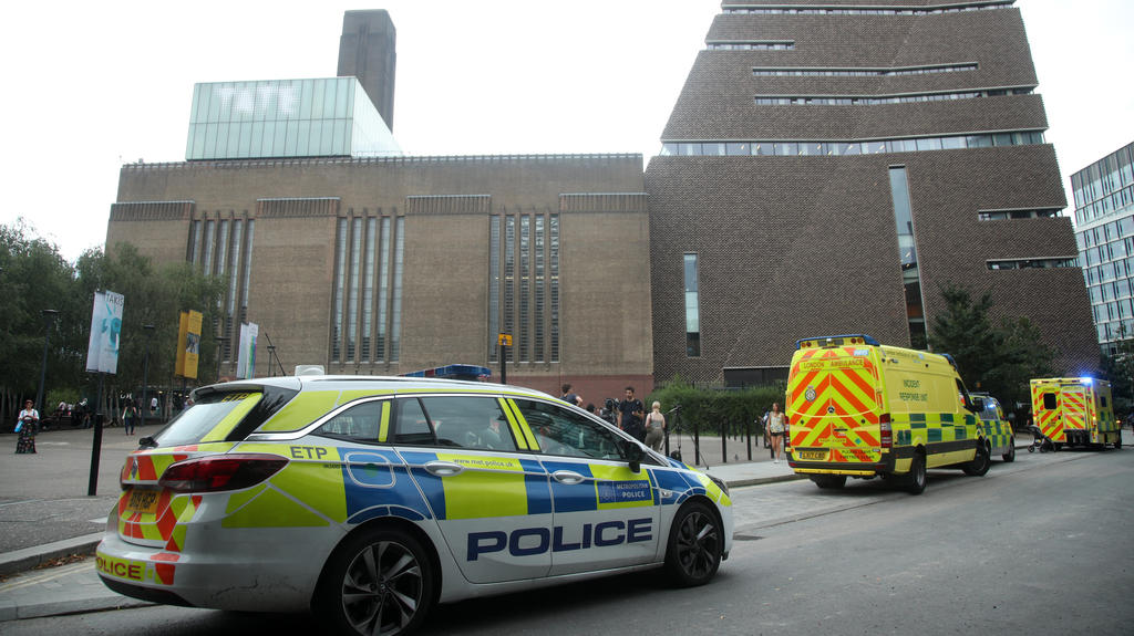 04.08.2019, Großbritannien, London: Einsatzwagen stehen vor dem Tate Modern Museum. Ein 17-Jähriger soll einen sechsjährigen Jungen von einer Aussichtsplattform im zehnten Stock geworfen haben. Der Jugendliche wurde wegen des Verdachts auf versuchten
