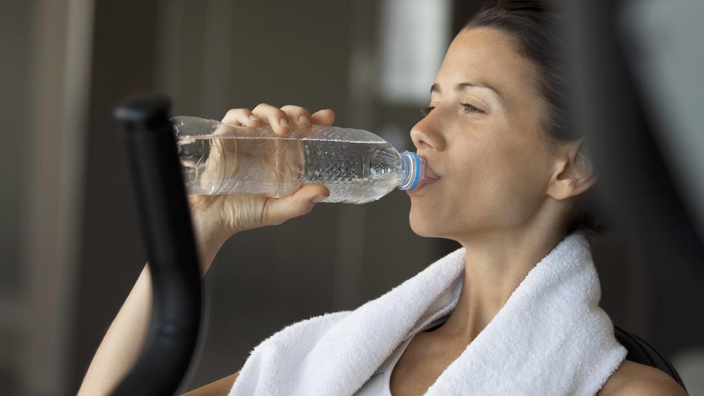 Woman drinking water in health club PUBLICATIONxINxGERxSUIxAUTxONLY Copyright: AlexVentura B69169327