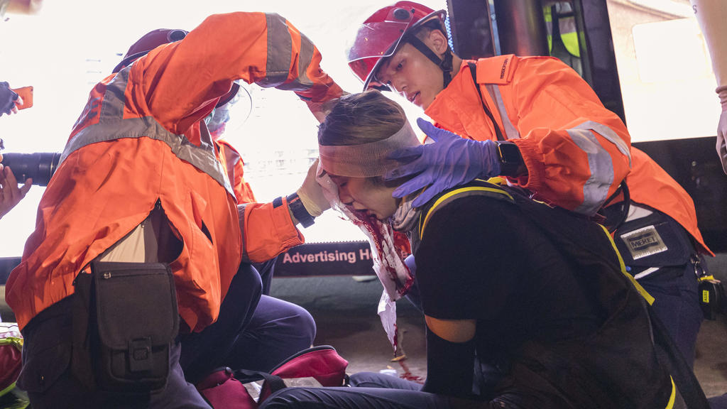 11.08.2019, China, Hongkong: Rettungskräfte versorgen eine verletzte Demonstrantin während erneuter Proteste. Seit zwei Monaten kommt es in der Metropole immer wieder zu großen Protesten und Ausschreitungen mit der Polizei. Auslöser für die Demonstra