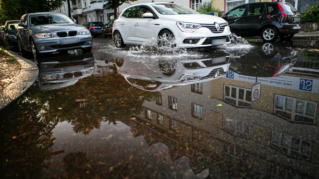 Regenschauer sorgt für Oberflächenwasser, Fahrbahn wird durch einen kräftigen Regenschauer überflutet. Berlin Tempelhof Deutschland *** Rain shower provides surface water, roadway is flooded by a heavy rain shower Berlin Tempelhof Germany