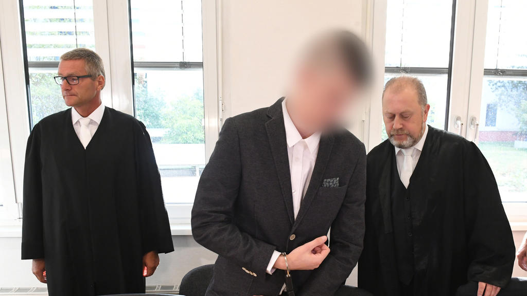 20.08.2019, Mecklenburg-Vorpommern, Stralsund: Der 21-jährige Angeklagte kommt in Handschellen und Fußfesseln in den Gerichtssaal im Landgericht Stralsund. Für den Mord an der 18-jährigen Maria aus Zinnowitz auf Usedom müssen sich am selben Tag der 1