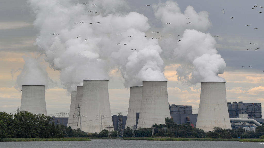 ARCHIV - 12.08.2019, Brandenburg, Peitz: Wildgänse fliegen in Richtung der dampfenden Kühltürme des Braunkohlekraftwerkes Jänschwalde der Lausitz Energie Bergbau AG (LEAG). Die Umweltstiftung WWF warnt in ihrem Dürrereport vor einer Wasserkrise und f