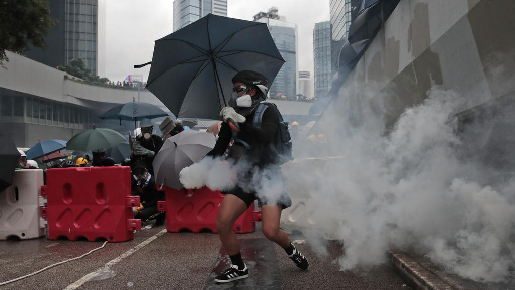 31.08.2019, China, Hongkong: Ein Demonstrant hält eine Tränengasgranate in der Hand. Trotz des Verbots einer Großdemonstration kommt es in Hongkong erneut zu Protesten gegen die Regierung. Foto: Jae C. Hong/AP/dpa +++ dpa-Bildfunk +++