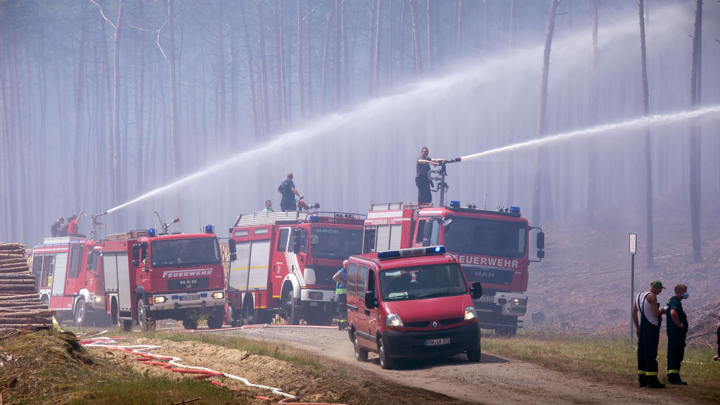 ARCHIV - 01.07.2019, Mecklenburg-Vorpommern, Alt Jabel: Feuerwehrleute löschen in der Nähe der evakuierten Ortschaft Alt Jabel einen großflächigen Waldbrand. Am 07.09.2019 haben Landesregierung Mecklenburg-Vorpommern und Landkreis Ludwigslust-Parchim