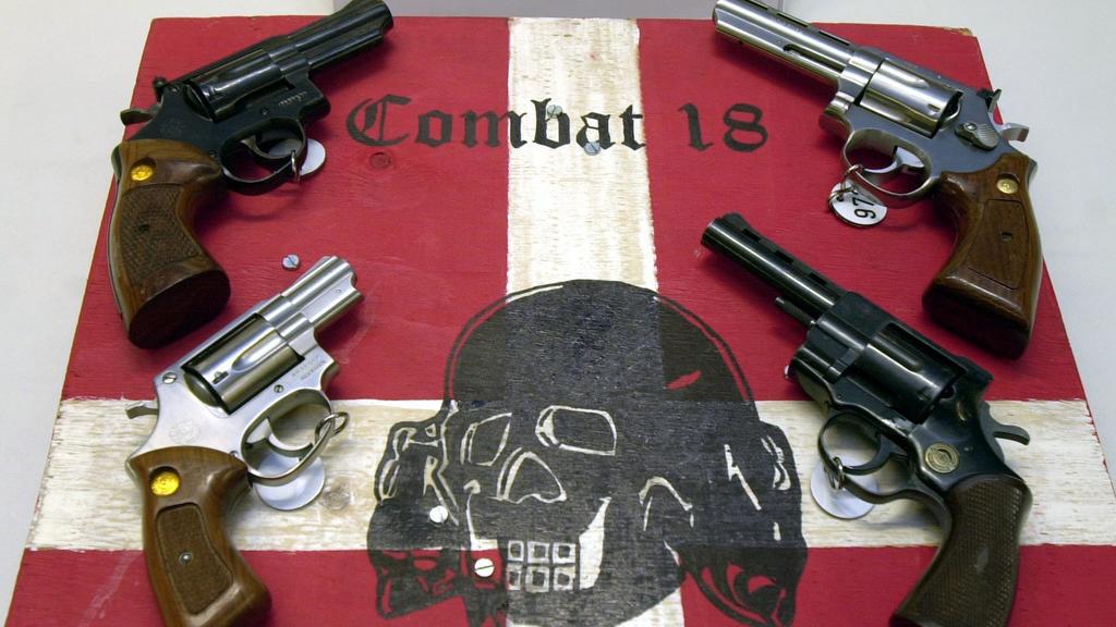 ARCHIV - 27.10.2003, Schleswig-Holstein, Kiel: Sichergestellte Waffen und ein Schild der kriminellen Neonazi-Gruppe «Combat 18» liegen im schleswig-holsteinischen Landeskriminalamt (LKA). Der niedersächsische Innenminister Pistorius (SPD) pocht auf e
