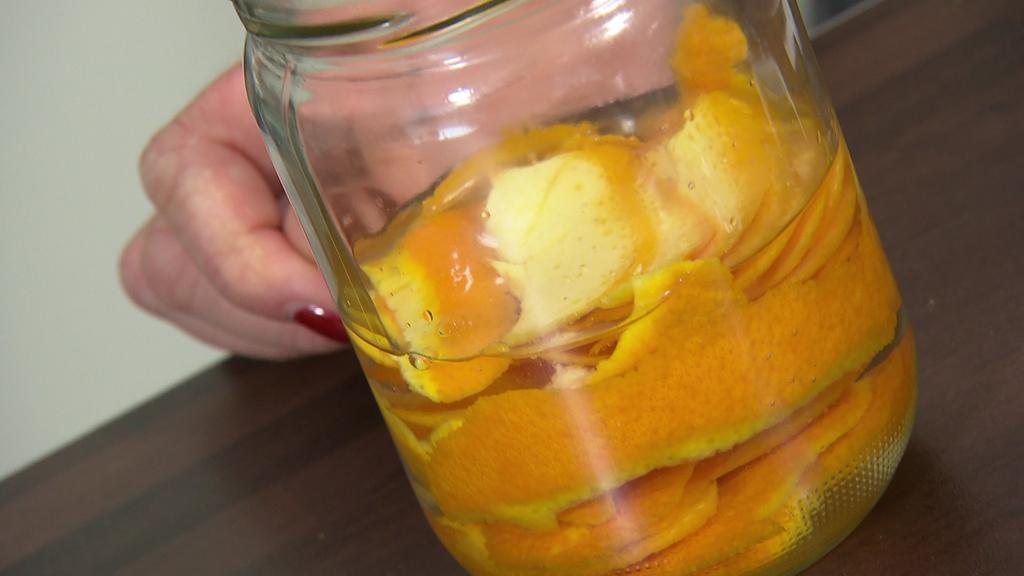 Ein Schraubglas gefüllt mit Essig und Orangenschalen.