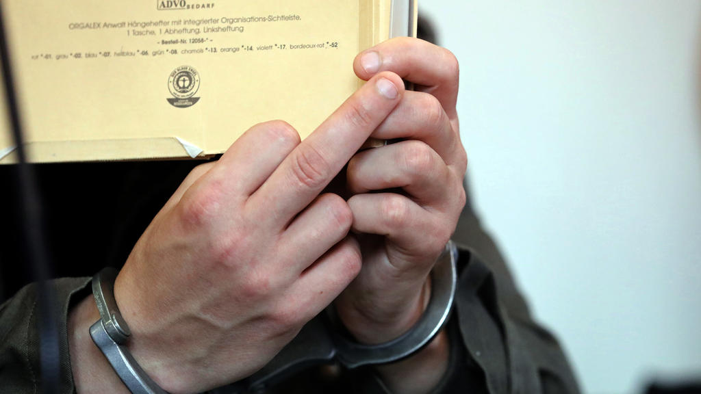 Mecklenburg-Vorpommern, Neubrandenburg: Vor Beginn des Prozesses wegen Mordes durch Unterlassen und Misshandlung von Schutzbefohlenen in sieben Fällen hält sich der angeklagte Stiefvater einen Aktendeckel vor das Gesicht
