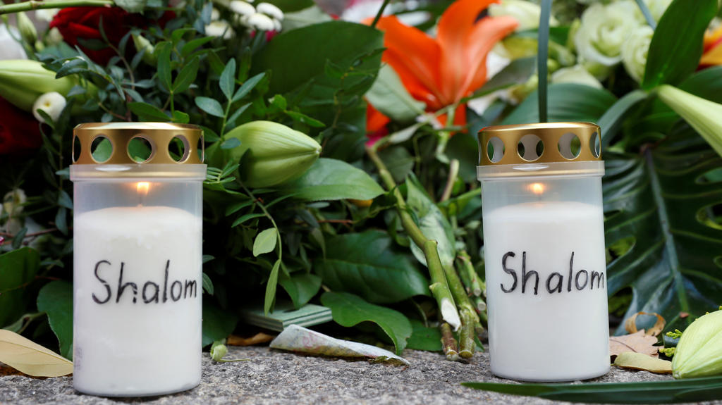 Flowers and candles are seen outside the synagogue in Halle, Germany October 10, 2019, after two people were killed in a shooting. REUTERS/Fabrizio Bensch