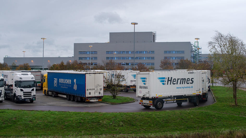 16.10.2019, Sachsen-Anhalt, Haldensleben: Hermes-Lastwagen stehen auf dem LKW-Parkplatz vor dem Tor des Versandzentrums des Paketdienstleisters Hermes dicht an dicht. Nach zwei Todesfällen innerhalb weniger Tage fand dort ein Feuerwehreinsatz statt.