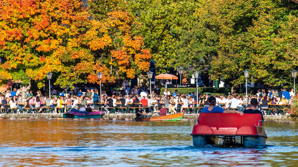 13.10.2019, Bayern, München: Personen in Tretbooten fahren vor dem Biergarten vom Seehaus im Englischen Garten auf dem Kleinhesseloher See. Foto: Lino Mirgeler/dpa +++ dpa-Bildfunk +++