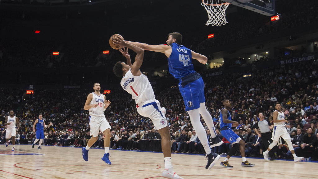 18.10.2019, Kanada, Vancouver: Basketball: NBA, Los Angeles Clippers - Dallas Mavericks, Testspiel: Dallas Mavericks Maxi Kleber (oben) aus Deutschland in Aktio mit Los Angeles Clippers Jerome Robinson (2.v.l). Foto: Darryl Dyck/The Canadian Press/AP