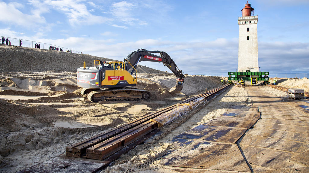 21.10.2019, Dänemark, Loenstrup: Ein Bagger ist an den Vorbereitungen für den Umzug eines Leuchtturms im Einsatz. Der Umzug eines 23 Meter hohen Leuchtturms hat begonnen. Der Rubjerg Knude Fyr war 1899 auf einer Wanderdüne errichtet worden. Aufgrund